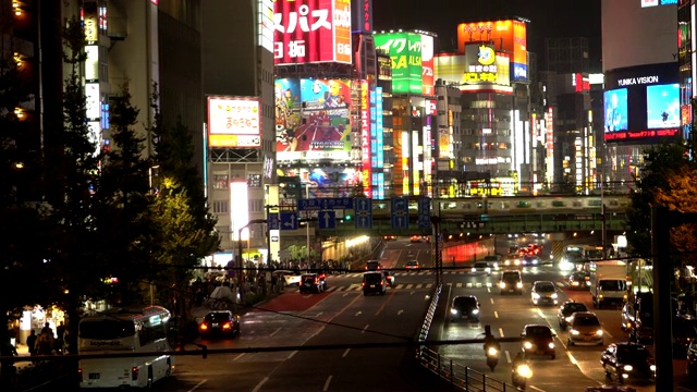 夜晚的交通道路和拥挤的横幅标志上的高楼大厦，在城市的同时下雨视频素材