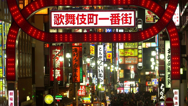 在东京新宿歌舞伎町，人群穿过马路视频素材