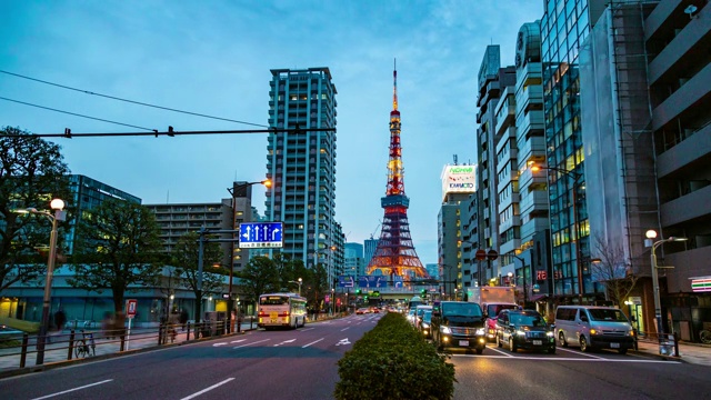 时光流逝的东京塔，日本著名的地标，耸立在深夜的天空和东京城市的灯光与繁忙的交通视频素材