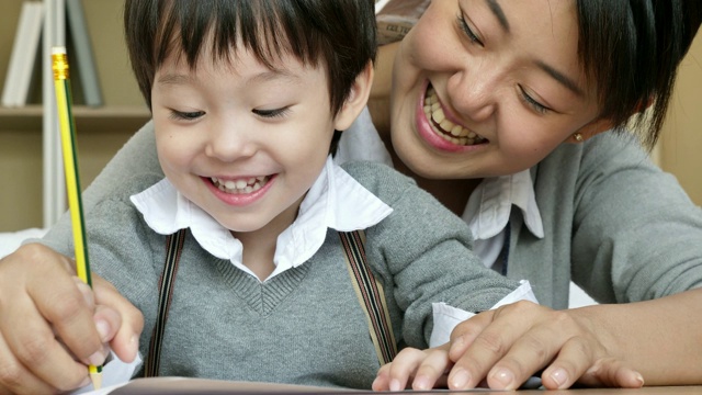 教育母子小男孩在家里看书画画做活动，幼稚园在家里做作业，母亲节，人们的家庭生活理念。视频素材