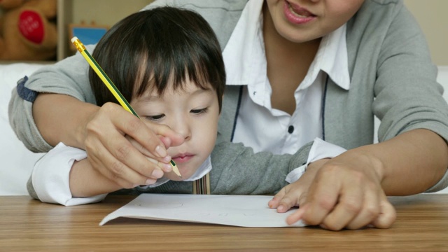 教育母子小男孩在家里看书画画做活动，幼稚园在家里做作业，母亲节，人们的家庭生活理念。视频素材