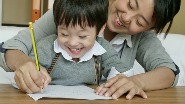 教育母子小男孩在家里看书画画做活动，幼稚园在家里做作业，母亲节，人们的家庭生活理念。视频素材