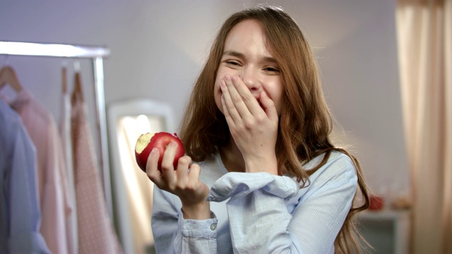 幸福的女人吃着红苹果。快乐的女人的情感。女性健康的饮食视频素材