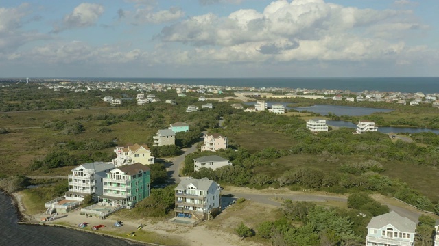 高档住宅的鸟瞰图，在城镇和海滩上空飞行。4 k视频素材