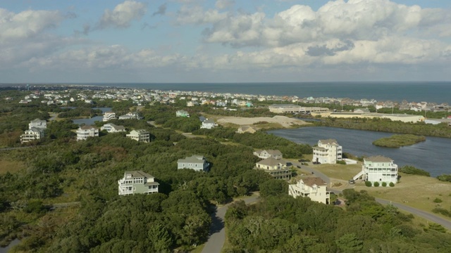 高档住宅的鸟瞰图，在城镇和海滩上空飞行。4 k视频素材