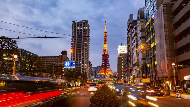 时光流逝的东京塔，日本著名的地标，耸立在深夜的天空和东京城市的灯光与繁忙的交通视频素材