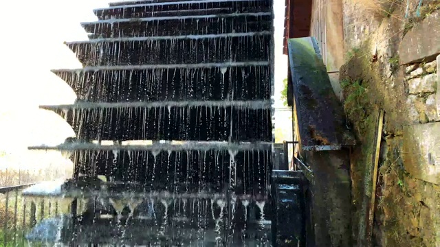 老式的木制水车转动着溅起水来视频素材