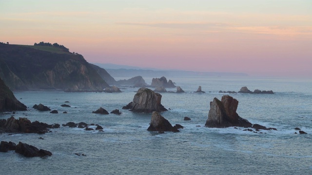 从Silencio海滩(Playa del Silencio)看到日出时水中的岩石。视频素材