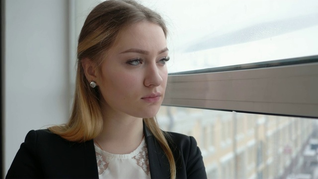 身着西装的沉思女人望着办公室窗户。业务人员的概念视频素材