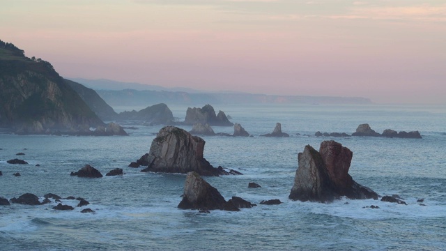 从Silencio海滩(Playa del Silencio)看到日出时水中的岩石。视频素材