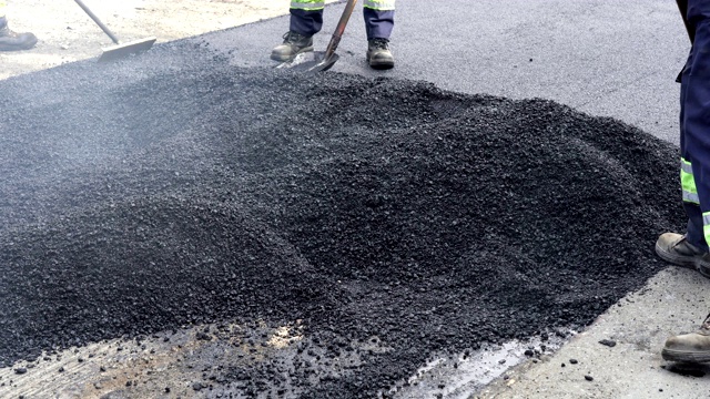 道路建筑工人正在平整沥青视频素材