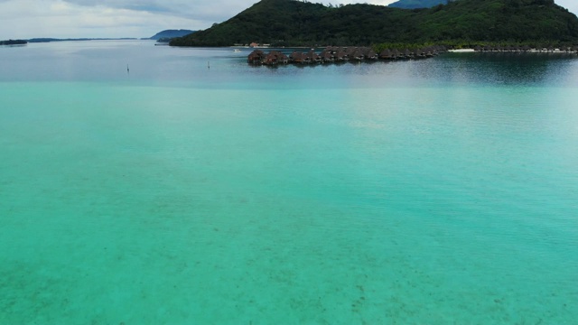 空中向前:大理石般的海水通向波拉波拉岛的热带小屋，法属波利尼西亚视频素材