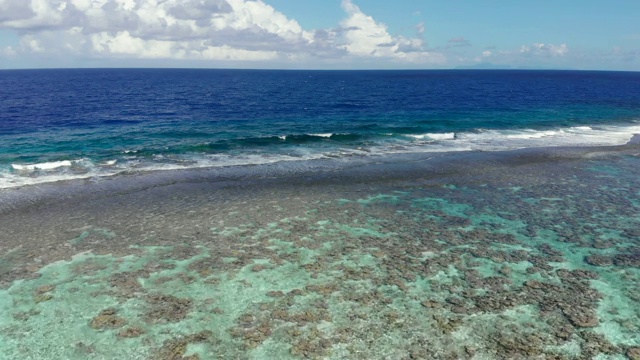 空中下降:在法属波利尼西亚，热带蓝色海浪撞击浅滩视频素材