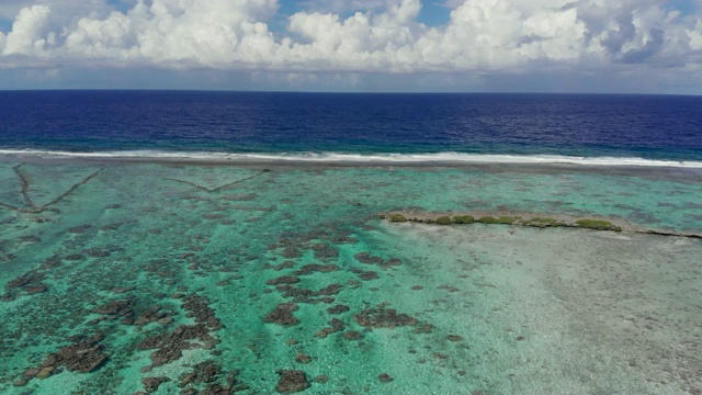 空中出口:在法属波利尼西亚，充满活力的蓝色热带海浪撞击浅滩视频素材