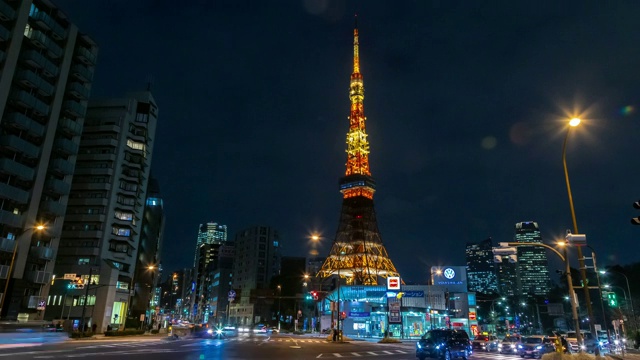 时光流逝的东京塔，日本著名的地标，耸立在深夜的天空和东京城市的灯光与繁忙的交通视频素材