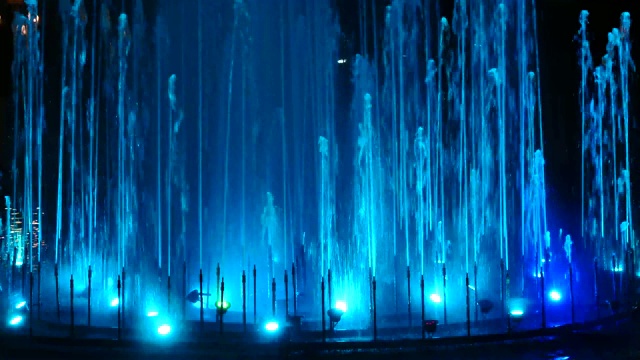 美丽的喷泉与光，稀薄的喷泉喷泉在夜空中升起，五颜六色的灯光喷泉在公园，4k视频素材