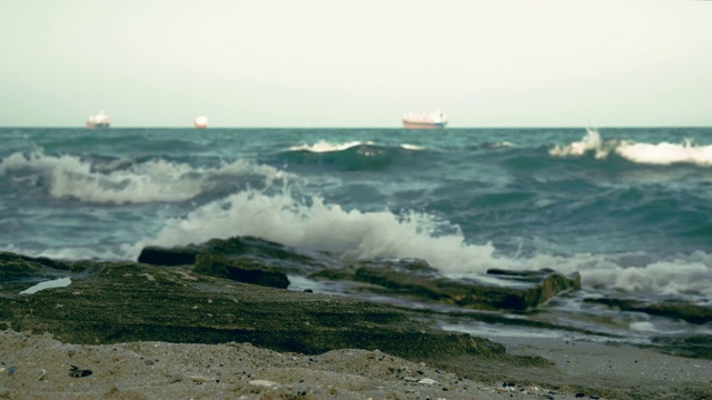 湛蓝的海面上明亮的黎明。海岸。水面上的小波浪。大型商业货船出现在地平线上。Copyspace视频素材