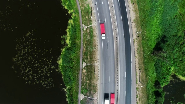 汽车在蓝色湖泊之间的高速公路上行驶视频素材