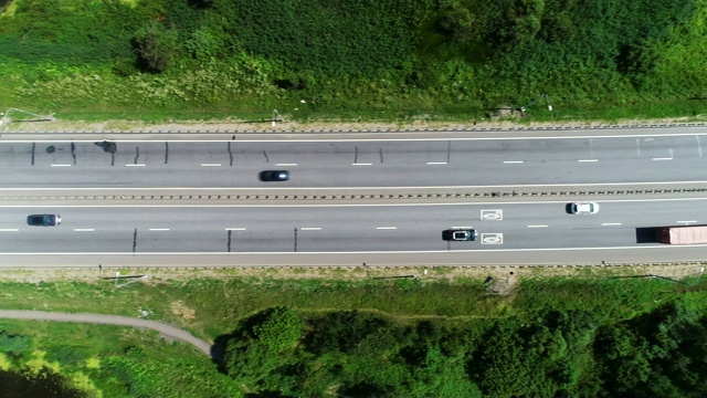 汽车在蓝色湖泊之间的高速公路上行驶视频素材