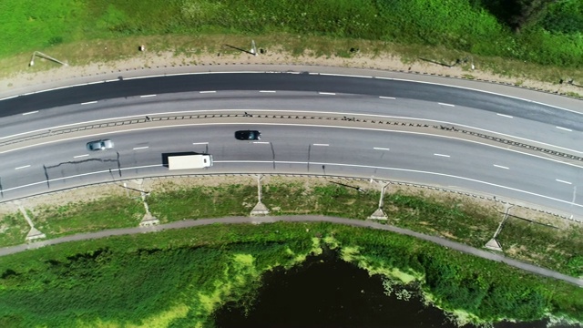 汽车在蓝色湖泊之间的高速公路上行驶视频素材