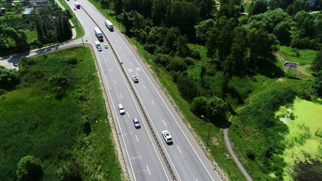 汽车在蓝色湖泊之间的高速公路上行驶视频素材