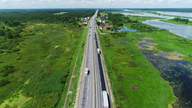 汽车在蓝色湖泊之间的高速公路上行驶视频素材