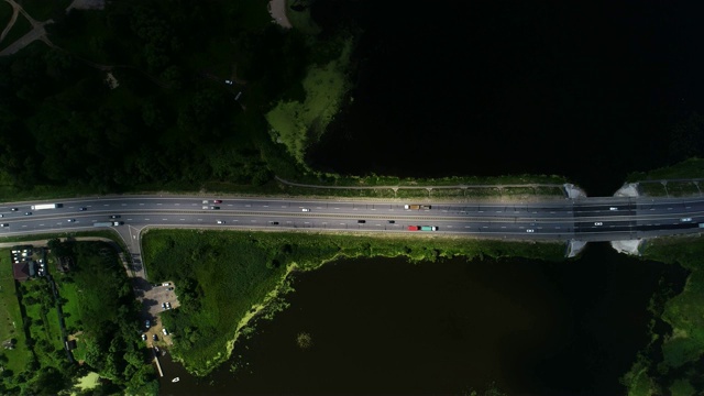 汽车在蓝色湖泊之间的高速公路上行驶视频素材