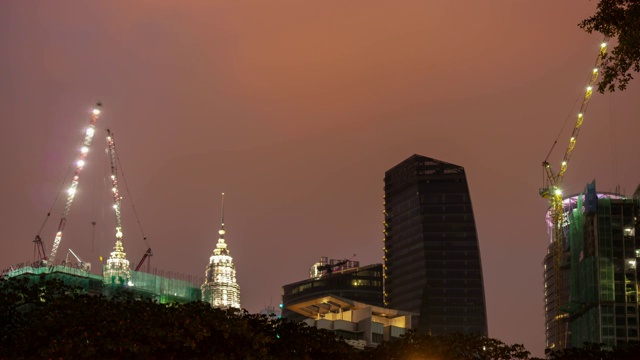 夜晚照亮了吉隆坡城市中心塔楼顶部的建筑全景，4k时间间隔的马来西亚视频素材