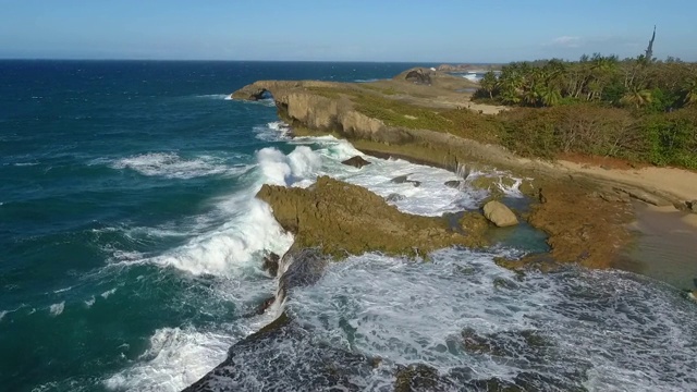 无人机飞越波多黎各海滩岩石形成的巨浪视频素材