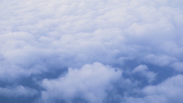 从窗外飞过的飞机上看到的地球上空的白云。Cloudscape背景。从飞机窗口俯瞰多云的天空视频素材