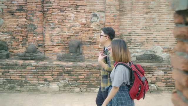 旅行者亚洲夫妇在泰国大城府度假，背包客甜蜜的夫妇享受他们的旅程在传统城市惊人的地标。生活方式情侣旅游度假概念。视频素材