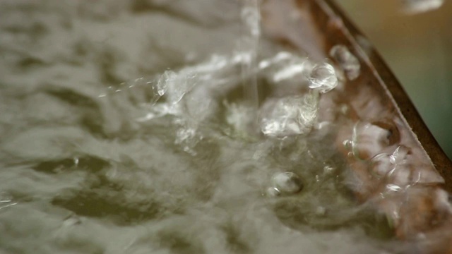 雨水流入生锈的旧桶里。雨滴特写镜头。视频素材