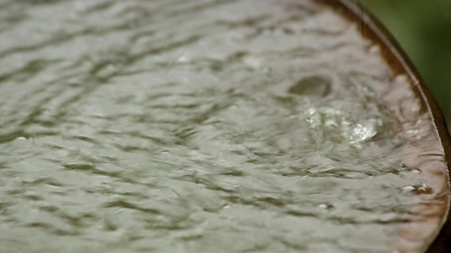 雨水流入生锈的旧桶里。雨滴特写镜头。视频素材