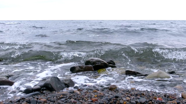 海浪拍打着石滩。视频素材