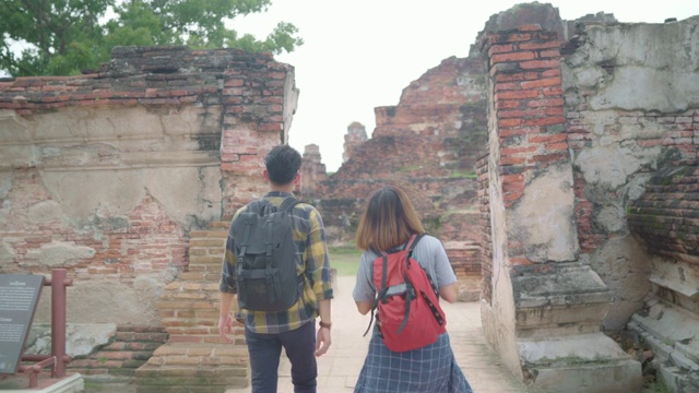 旅行者亚洲夫妇在泰国大城府度假，背包客甜蜜的夫妇享受他们的旅程在传统城市惊人的地标。生活方式情侣旅游度假概念。视频素材