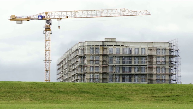 带有脚手架和建筑起重机的住宅建筑来自绿地视频素材