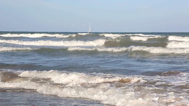 海浪靠近海岸，阳光在水中照耀。风景如画的白沙海岸冲刷着海浪。背景或纹理视频素材