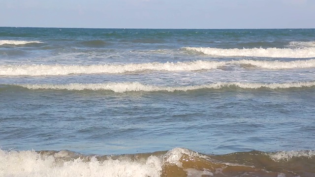 海浪靠近海岸，阳光在水中照耀。风景如画的白沙海岸冲刷着海浪。背景或纹理视频素材