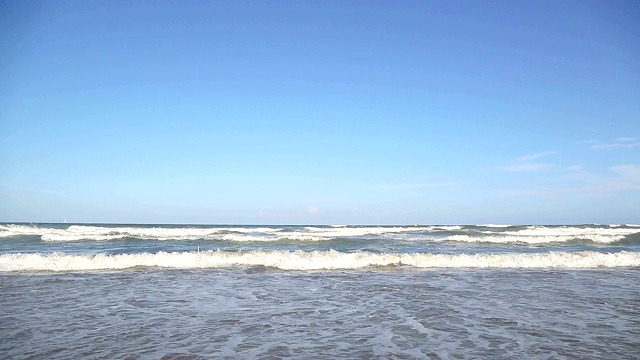 海浪靠近海岸，阳光在水中照耀。风景如画的白沙海岸冲刷着海浪。背景或纹理视频素材