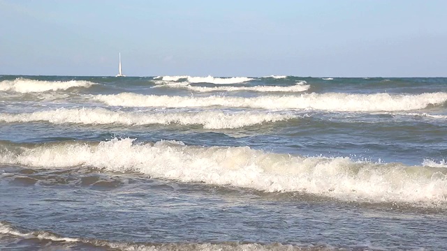 海浪靠近海岸，阳光在水中照耀。风景如画的白沙海岸冲刷着海浪。背景或纹理视频素材