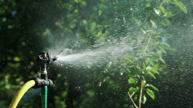 自动灌溉系统在夏天在院子里喷水。视频素材