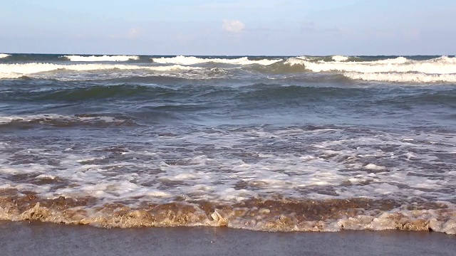 海浪靠近海岸，阳光在水中照耀。风景如画的白沙海岸冲刷着海浪。背景或纹理视频素材