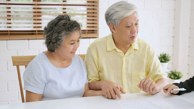 亚洲资深夫妇在家里得到理财规划师的建议。老在家里。视频素材