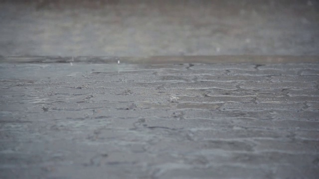 雨水落在水泥地板上，后面的街道被水淹没视频素材