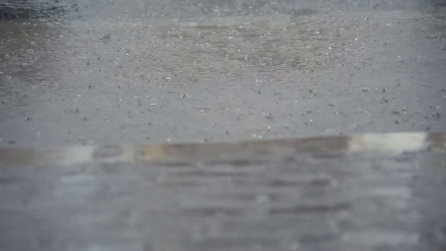 雨水落在水泥地板上，后面的街道被水淹没视频素材