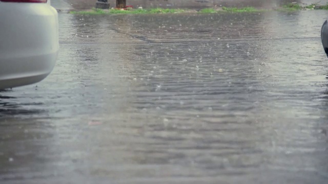 雨水落在水泥地板上，后面的街道被水淹没视频下载