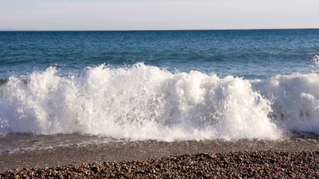 在阳光明媚的日子里，海滩上巨大的浪花在慢慢地移动视频素材