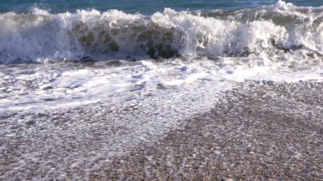 在阳光明媚的日子里，海滩上巨大的浪花在慢慢地移动视频素材