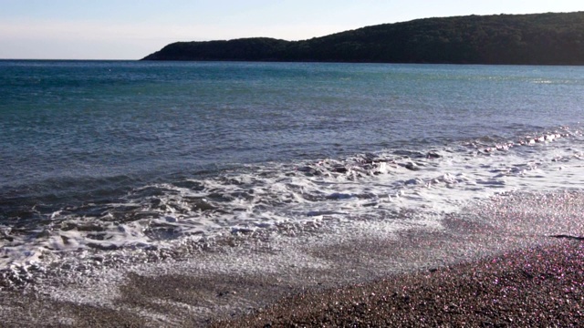 在阳光明媚的日子里，海滩上巨大的浪花在慢慢地移动视频素材