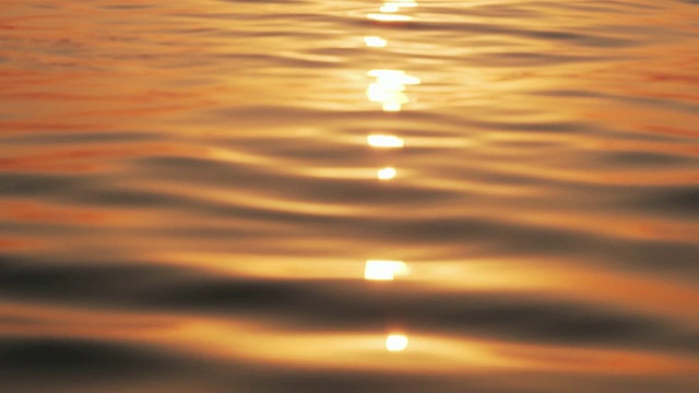 滑动缓慢运动的海面与小波浪的背景，日出的太阳。太阳从海面升起，太阳的路径在水面上。海面平静视频素材